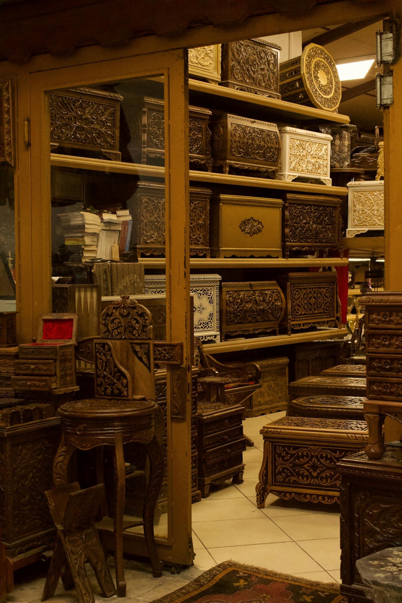 A shop filled with detailed carved wooden chests and tables showcasing craftsmanship.